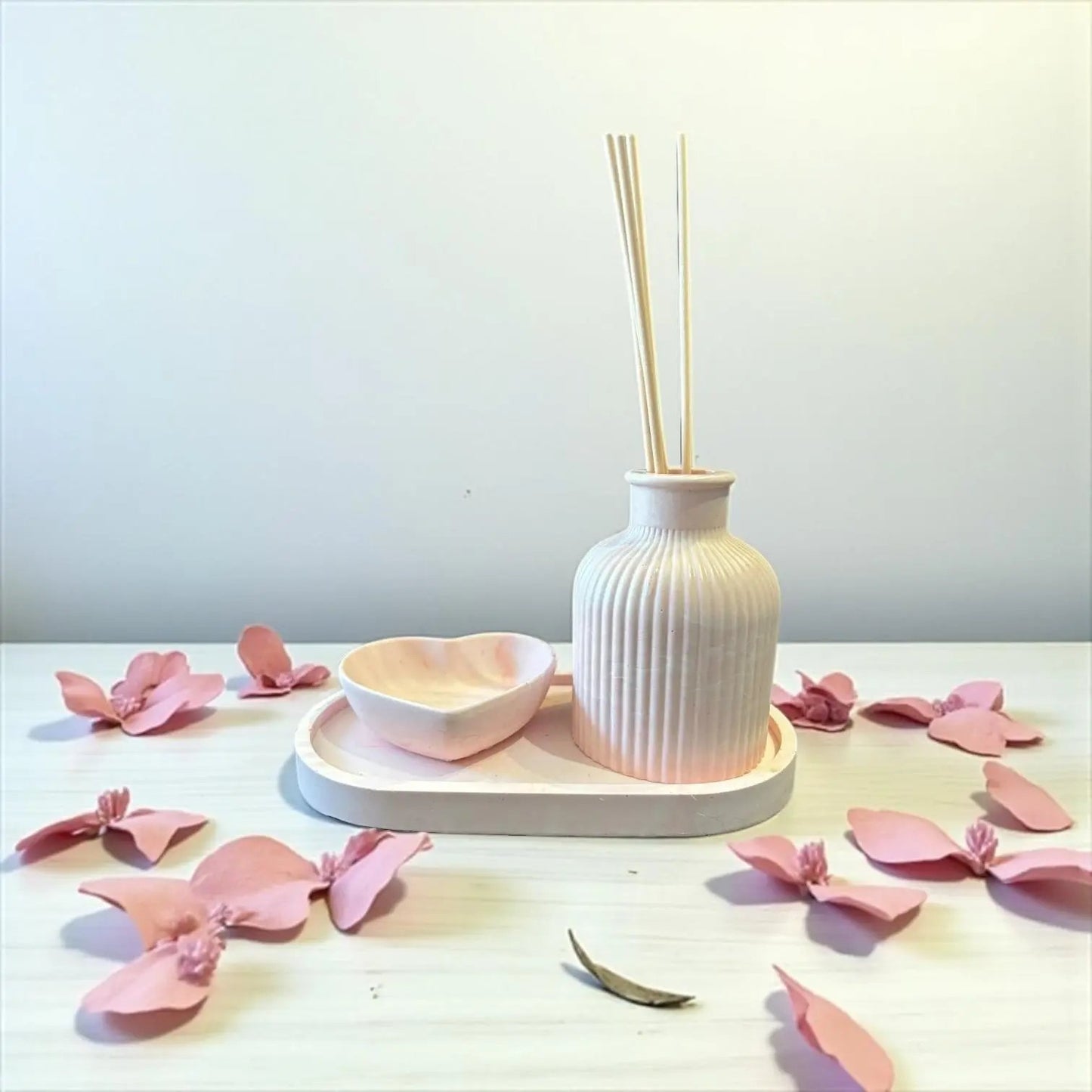 Diffuseur à parfum en Jesmonite rose pastel avec vide-poche et petit cœur assorti. Fait main en France. Design doux et élégant. Ajoute un parfum d’ambiance Les Bougies de Madley pour un coffret complet prêt à l’emploi.