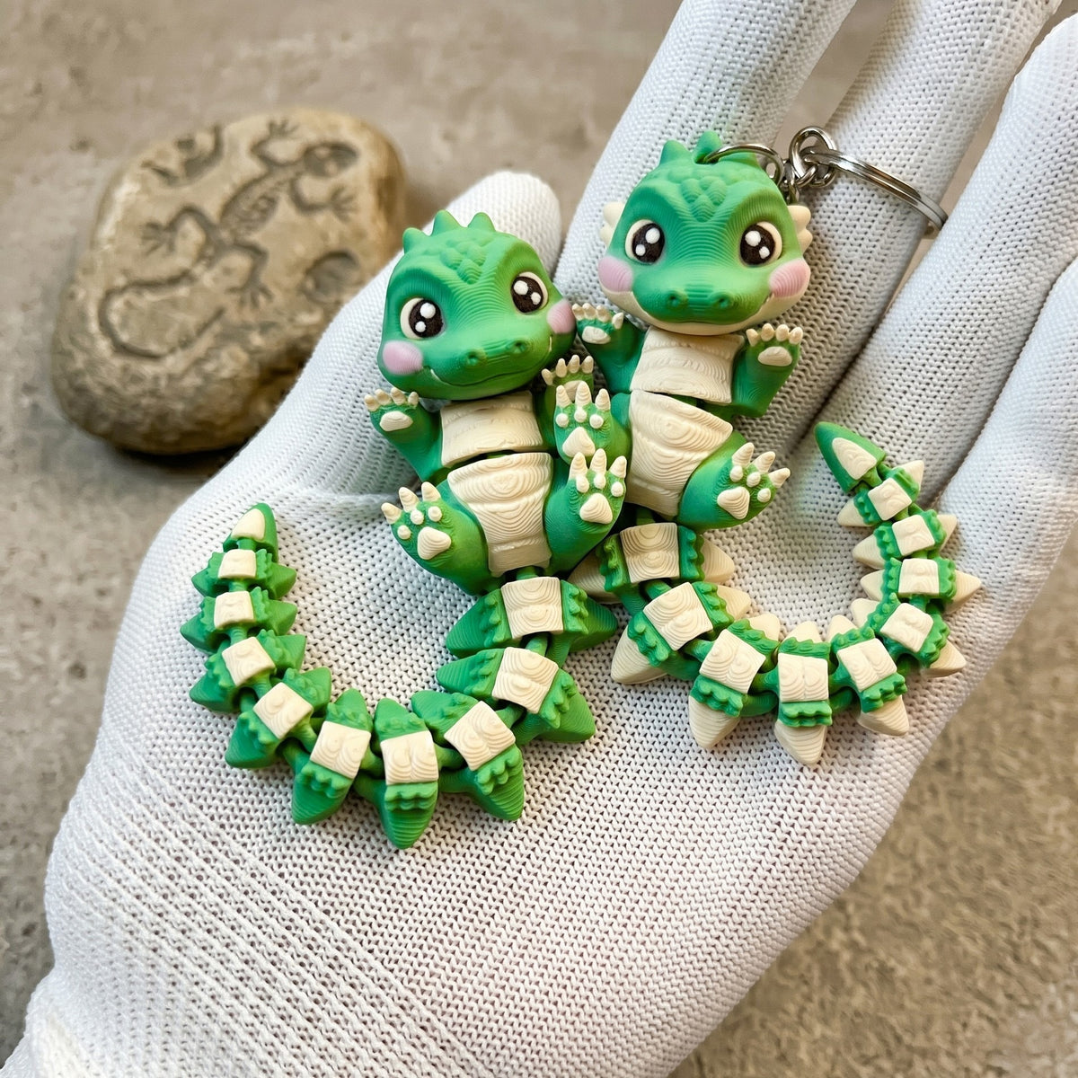 Deux bébés crocodiles articulés kawaii tenus dans une main avec anneaux porte-clés
