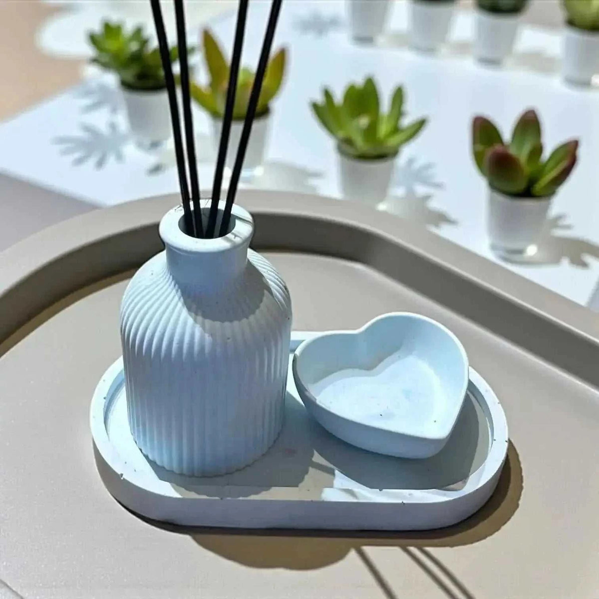 Diffuseur à Parfum en Jesmonite bleu pastel rainuré avec plateau ovale assorti et vide-poche en forme de cœur.