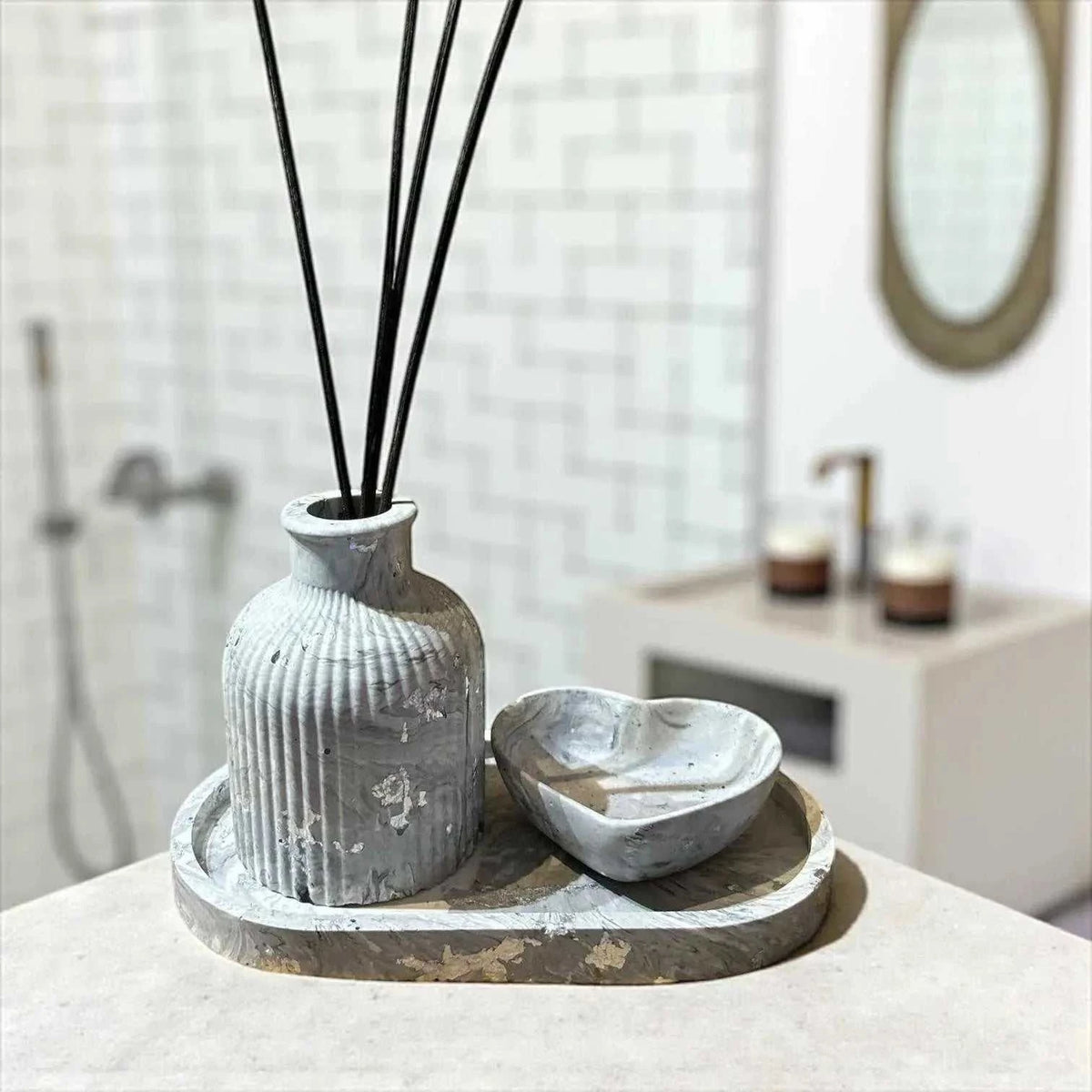 Diffuseur à parfum en Jesmonite marbré gris avec plateau ovale et vide-poche en forme de cœur, finition feuille argentée.