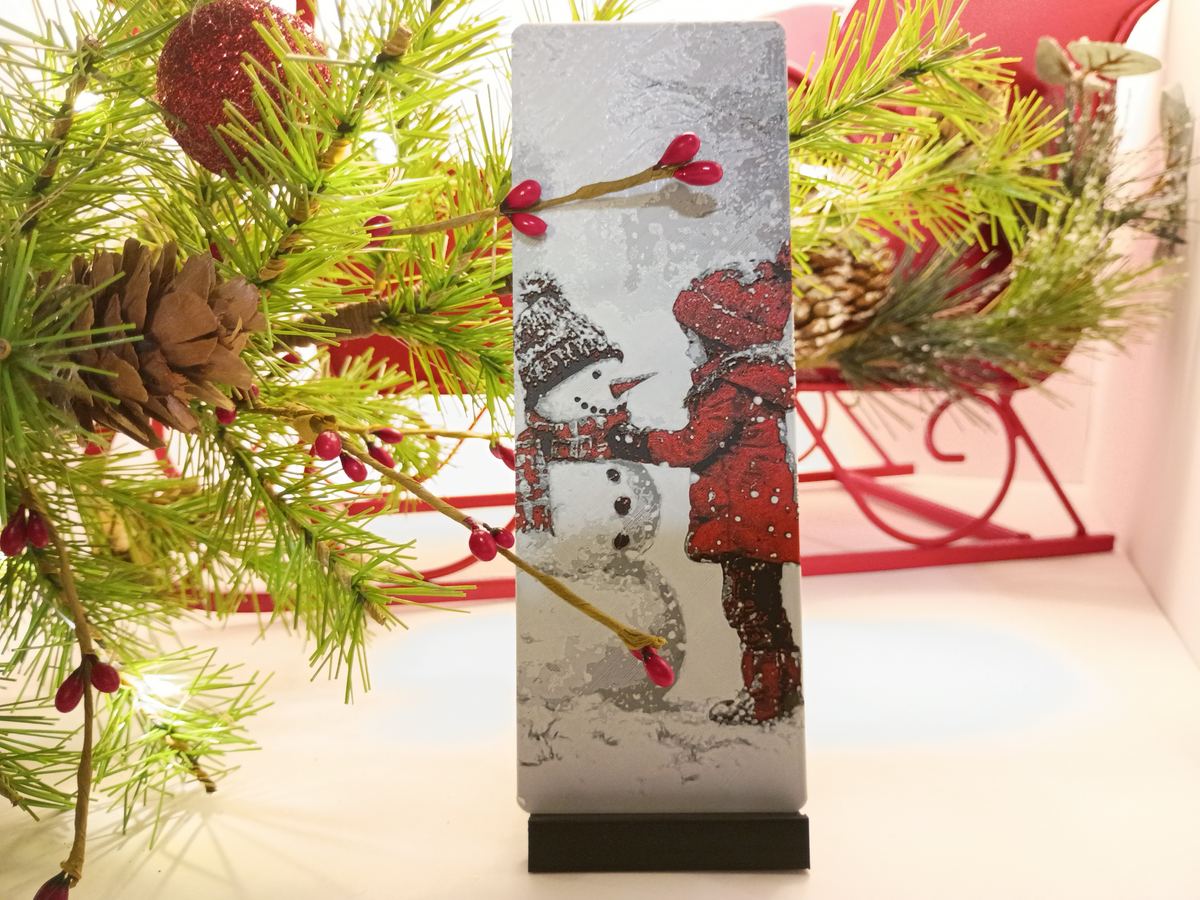 Marque-page de Noël fille et bonhomme de neige présenté près d'un sapin décoré
