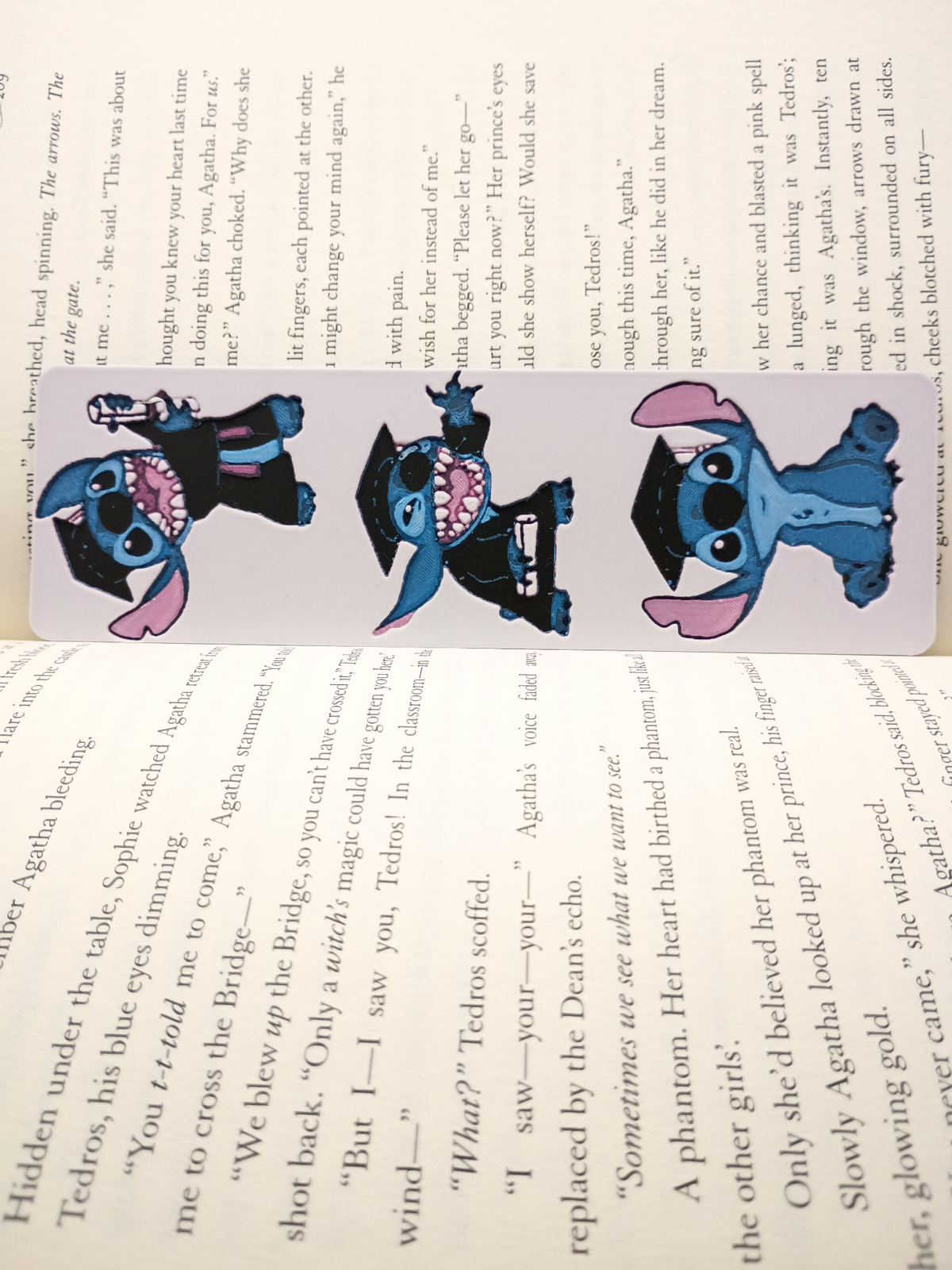 Marque-page Stitch diplômé avec trois illustrations dans un livre