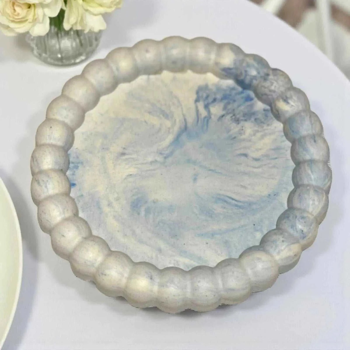 Vide-poche marguerite en Jesmonite bleu marbré clair, finition satinée, fait main, décoration zen et élégante.