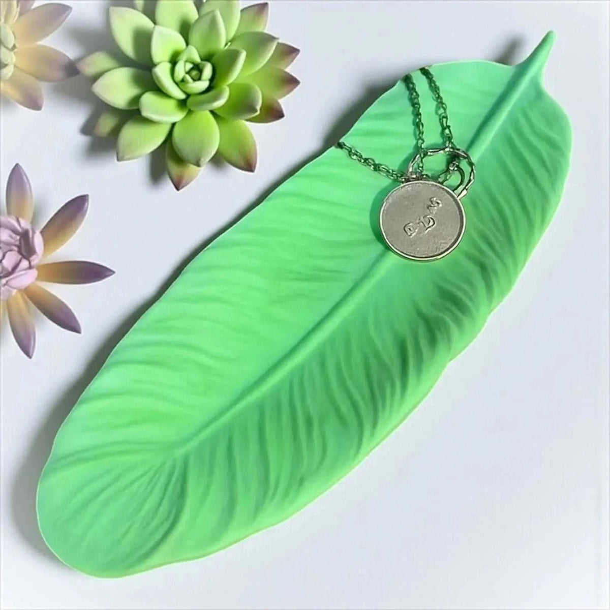 Vide-poche plume vert tendre en Jesmonite naturelle, création artisanale texturée, finition satinée effet pierre, décor zen, 24x8 cm.