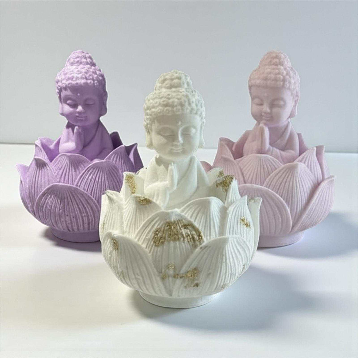 Trois figurines de bouddha en céramique avec base fleur de lotus et accents en feuille d or tons lavande blanc et rose pâle