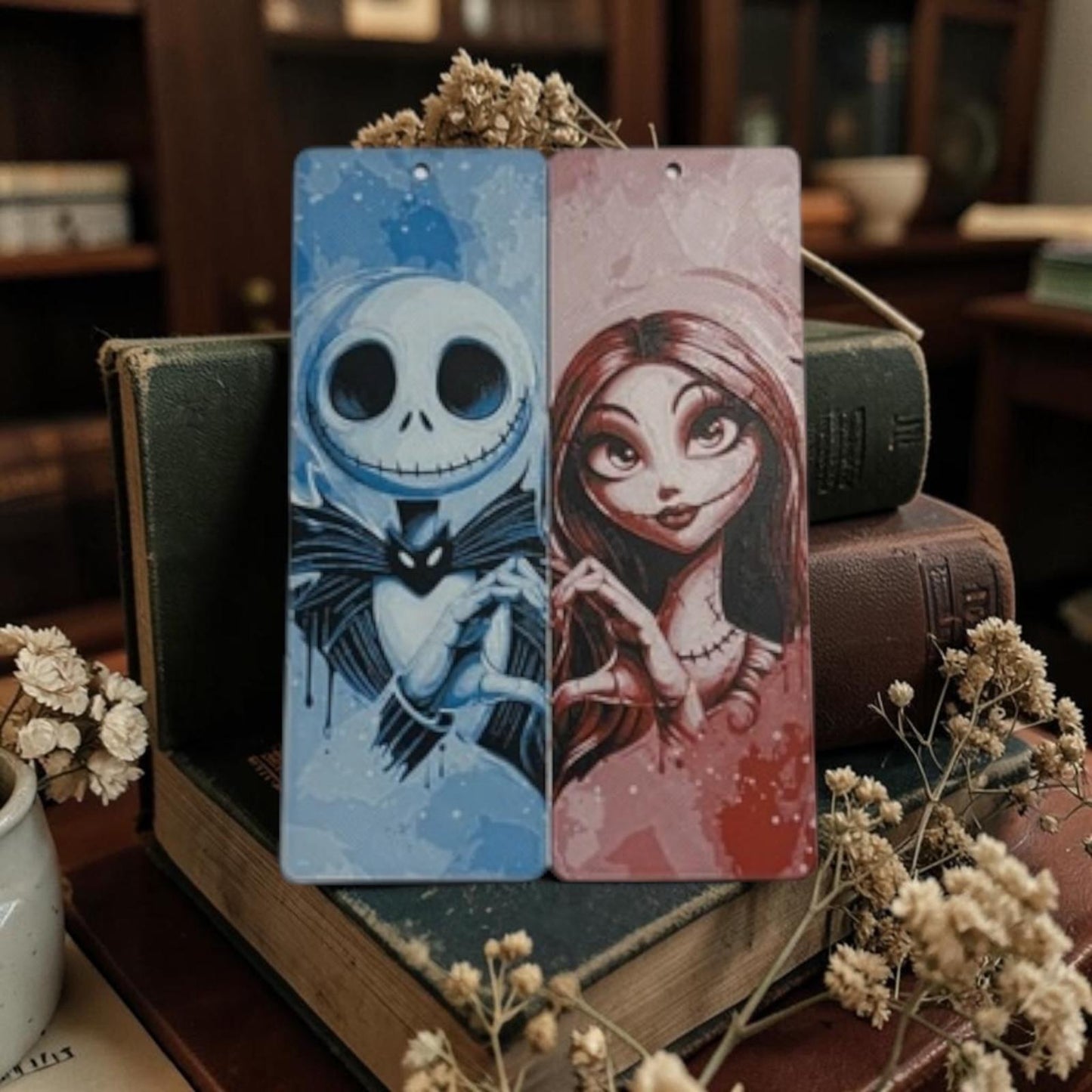 Marque-page Jack et Sally en couleur en impression 3D présenté sur une pile de livres