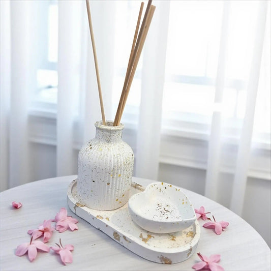 Coffret diffuseur à parfum en Jesmonite blanche décoré de feuilles d’or et paillettes dorées. Fait main en France. Inclut plateau et vide-poche cœur assorti. Option parfum d’ambiance Les Bougies de Madley.