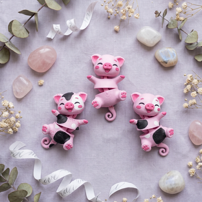 Cochon rose uni entouré de deux cochons roses à taches noires