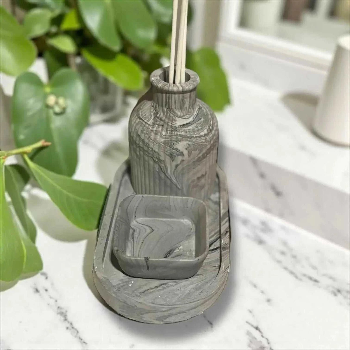 Diffuseur à parfum en Jesmonite avec effet marbré gris et noir, surface mate douce, accompagné d’un vide-poche carré assorti.