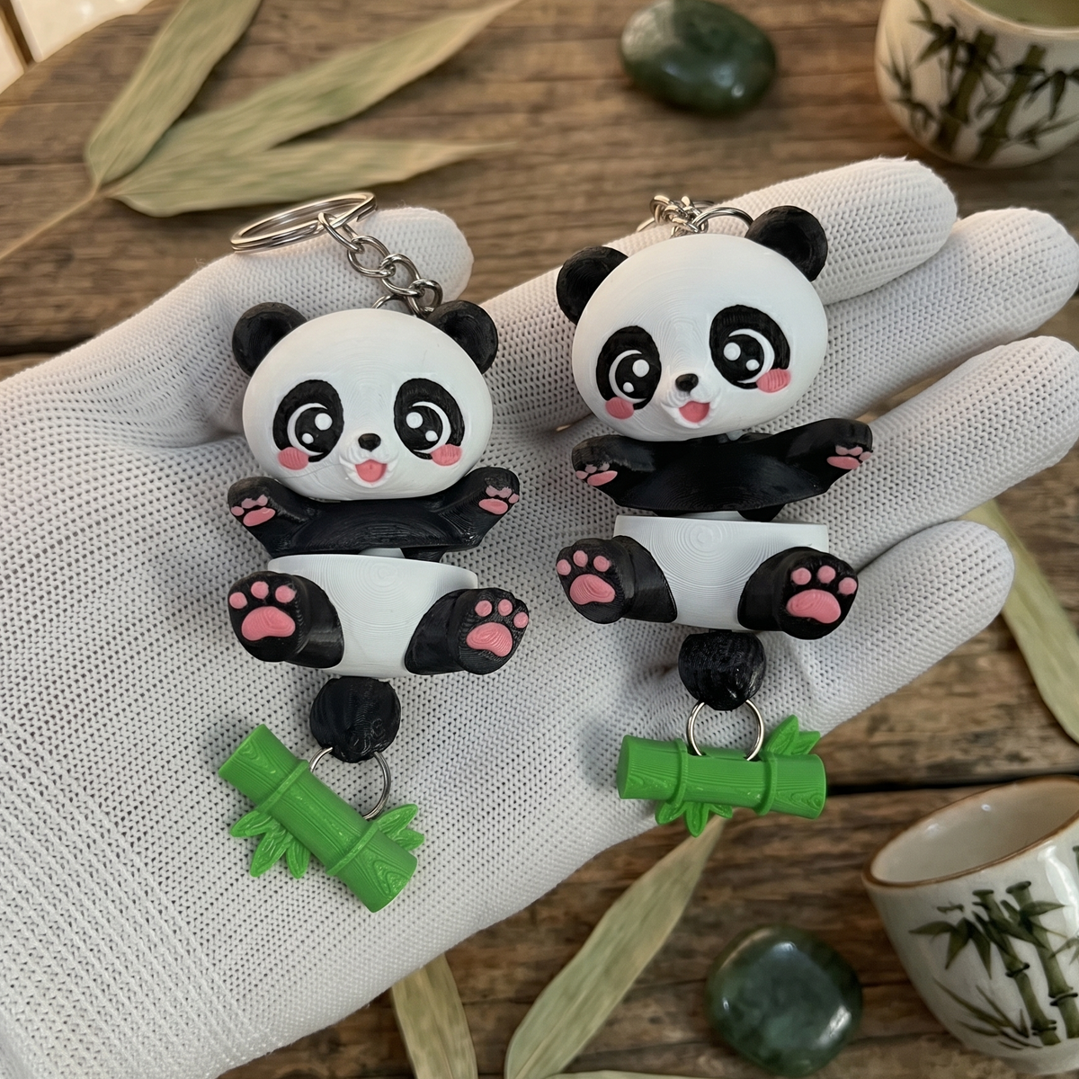 Deux pandas articulés kawaii avec accessoires bambou et chaînettes métalliques