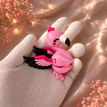 Porte-clés flamant rose articulé kawaii avec ailes noires et roses tenu dans une main