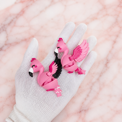 Deux modèles de flamants roses articulés kawaii avec ailes colorées dans une main