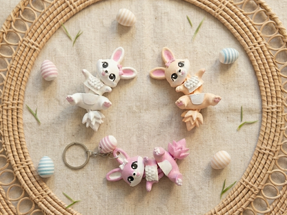 Lapins de Pâques articulés Fluffy Tails présentés dans un décor naturel avec œufs pastel