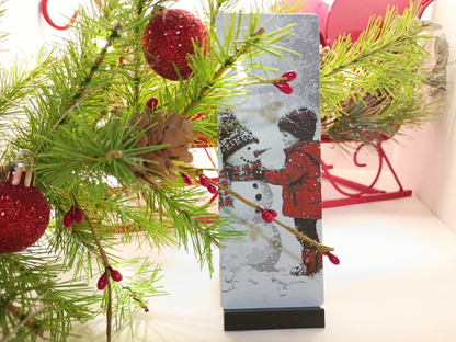 Marque-page de Noël garçon et bonhomme de neige présenté près d'un sapin décoré