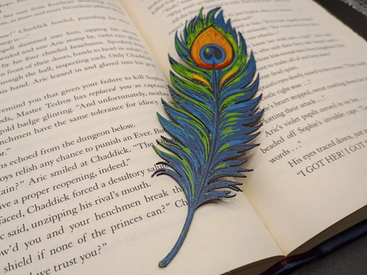 Marque-page 3D Plume de Paon coloré posé sur un livre ouvert