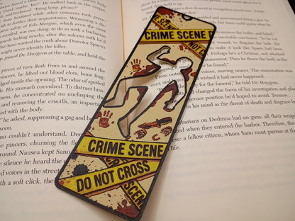 Marque-page 3D Scène de crime posé sur les pages d'un roman policier