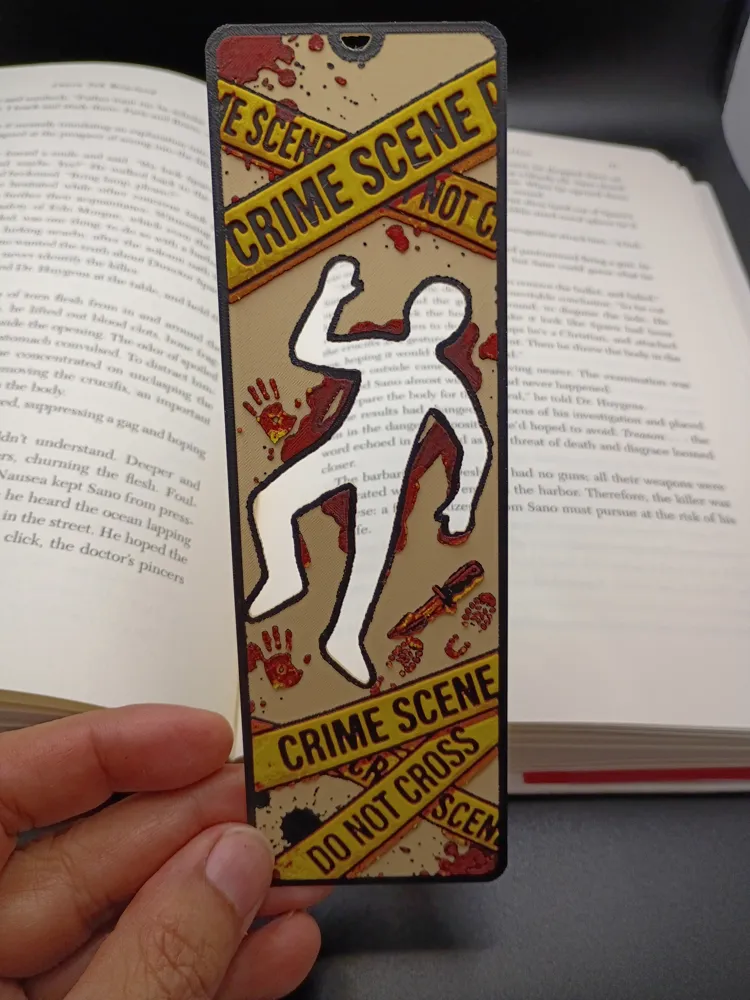 Marque-page 3D Scène de crime tenu en main devant un livre ouvert