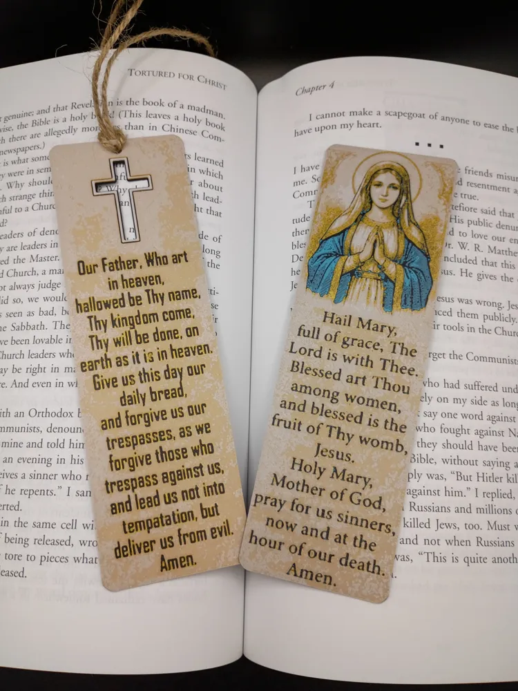 Deux marque-pages religieux Ave Maria et Notre Père posés dans un livre