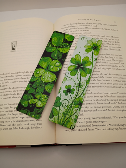 Marque-pages Lucky Clovers vert et noir et vert sur fond clair présentés sur un livre ouvert