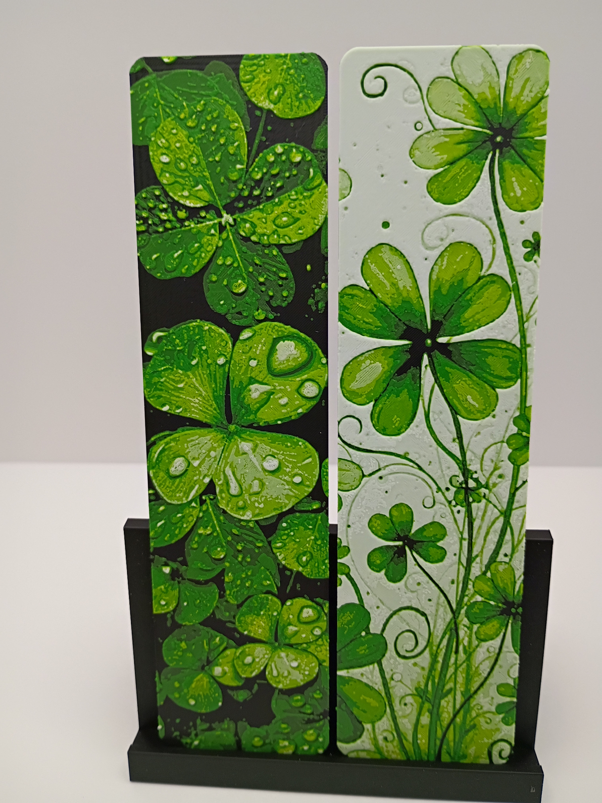 Deux marque-pages Lucky Clovers aux motifs de trèfles verts, présentés sur leur support noir