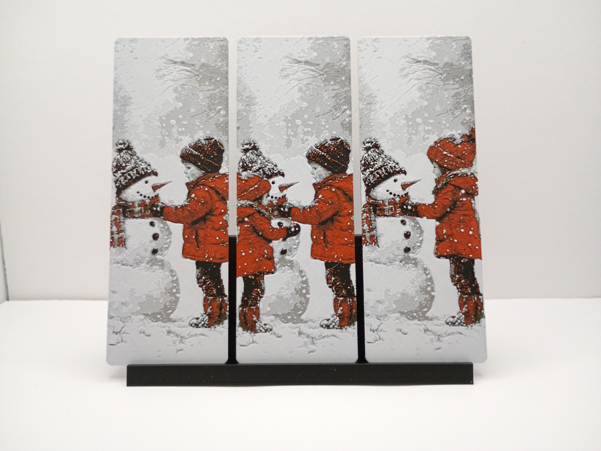 Trois marque-pages de Noël bonhomme de neige présentés côte à côte sur un support noir