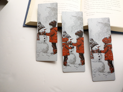 Trois modèles de marque-pages de Noël avec enfants et bonhomme de neige devant un livre ouvert