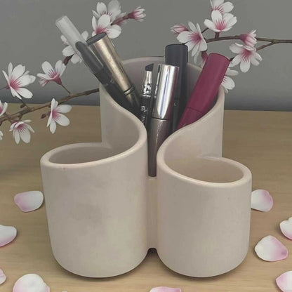 Organisateur à maquillage blanc cassé en Jesmonite mate, design épuré avec plusieurs compartiments pour pinceaux et rouges à lèvres.