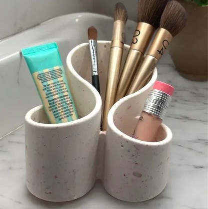 Organisateur à maquillage en Jesmonite beige avec motifs terrazzo marron, design moderne et courbes élégantes.