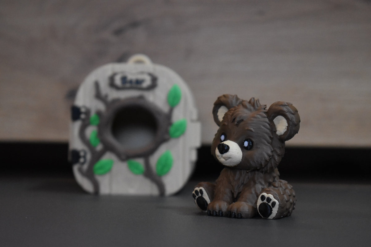 Mini figurine ours Pocket Pals en impression 3D avec maison forêt en arrière-plan