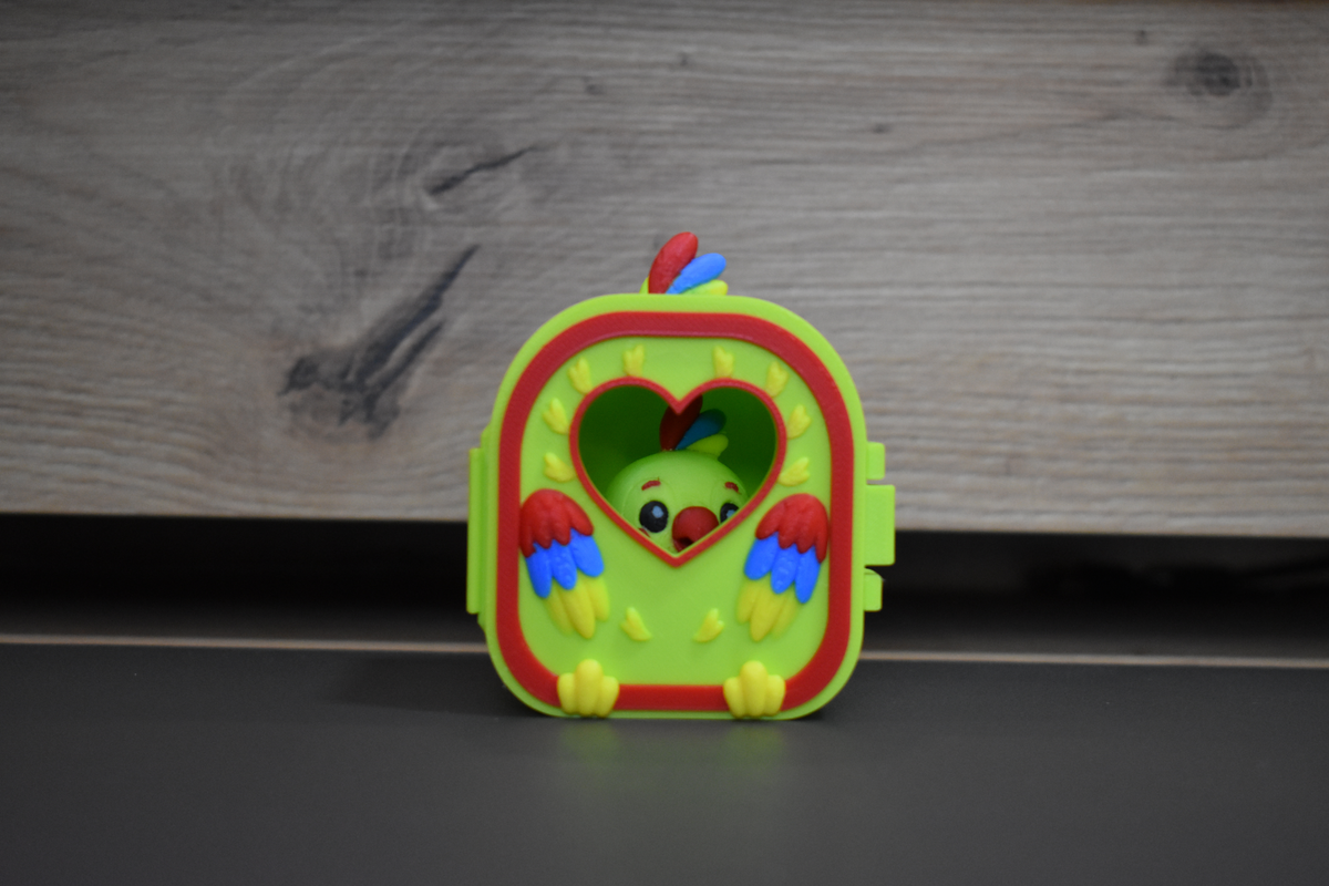 Pocket Pals Perroquet installé dans sa mini maison à fenêtre cœur