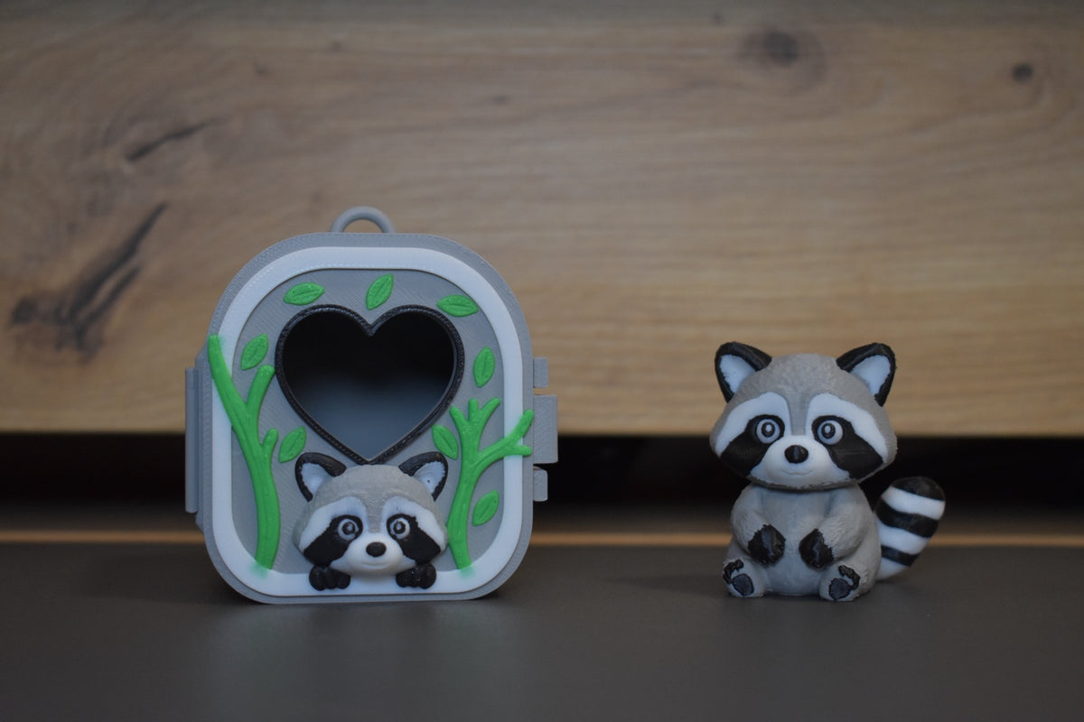 Pocket Pals raton laveur avec sa maison décorée de branches et feuilles – figurine 3D kawaii