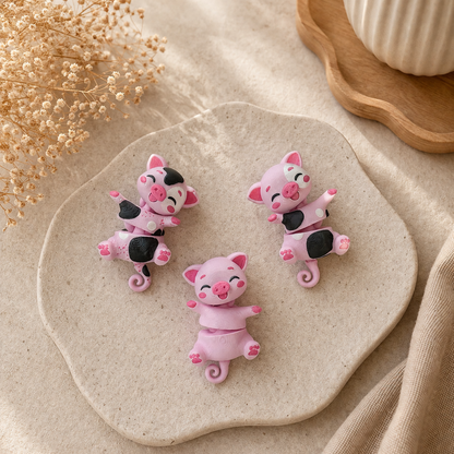 Trois porte-clés cochons articulés roses, un uni et deux à taches noires