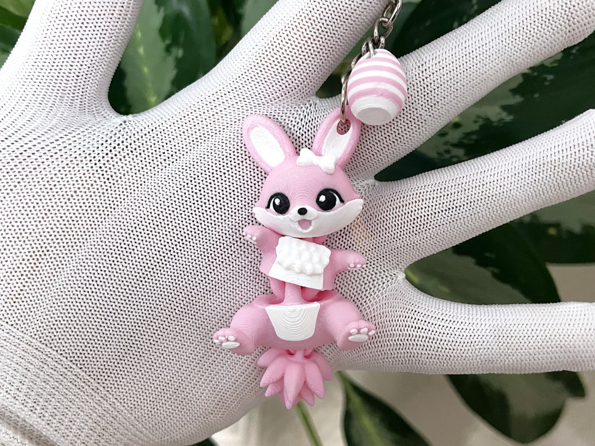 Porte-clé lapin de Pâques rose articulé Fluffy Tails avec œuf rayé