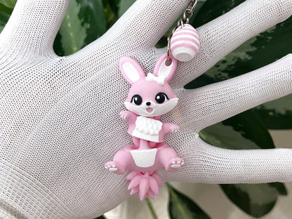 Porte-clé lapin de Pâques rose articulé Fluffy Tails avec œuf rayé