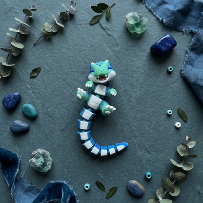 Porte-clé T-Rex turquoise et bleu articulé kawaii Fluffy Tails dans une main