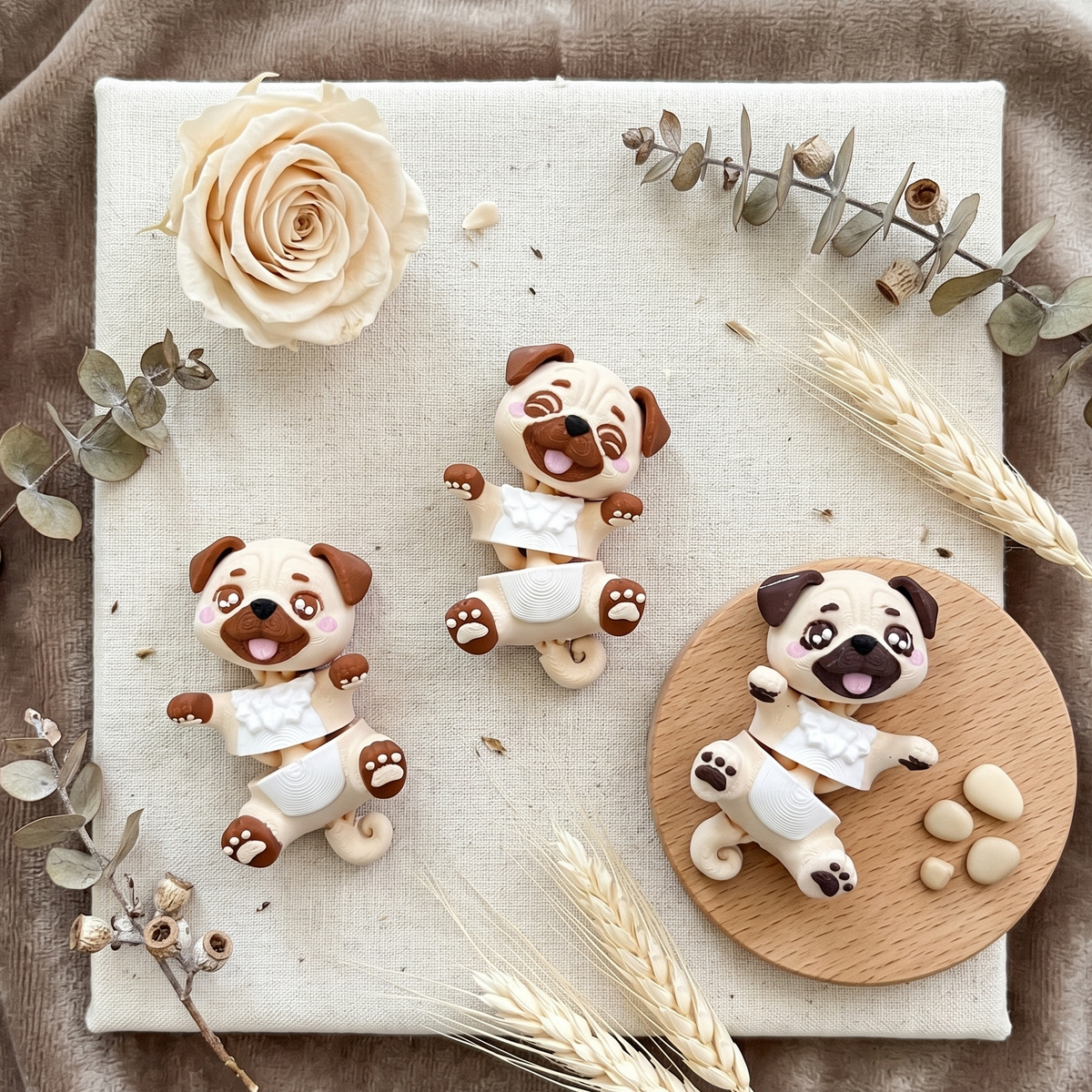 Trois carlins articulés kawaii dans une décoration naturelle et fleurie