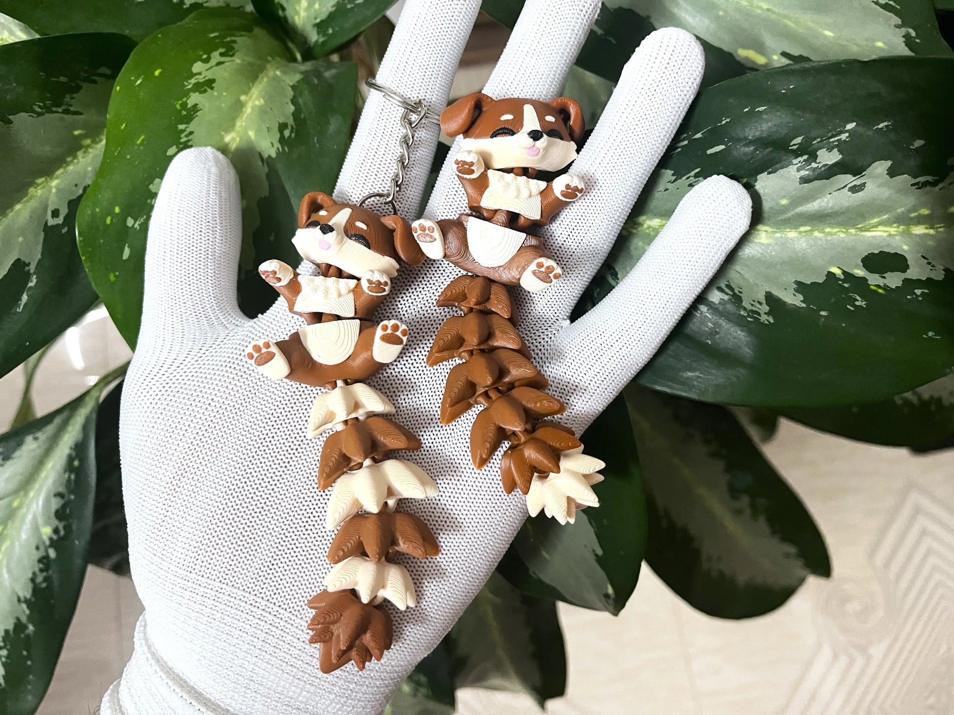 Petit chien articulé Flexi tenu dans une main devant des plantes vertes