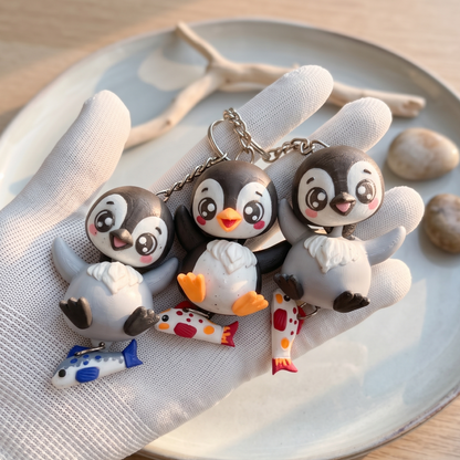 Porte-clés pingouins kawaii imprimés en 3D, quatre modèles noir et gris avec poissons bleu et corail