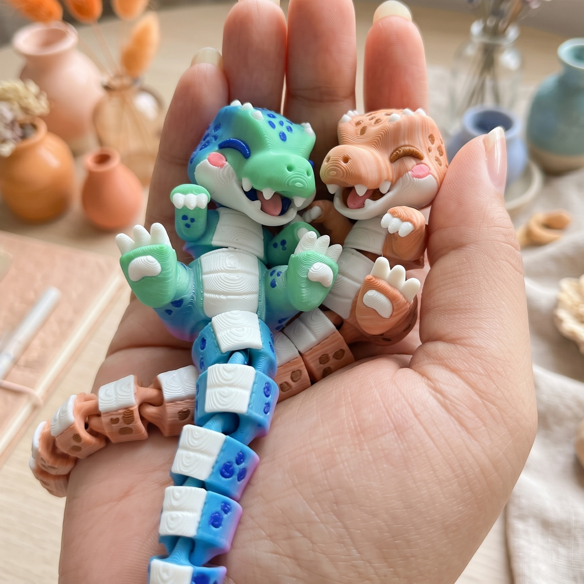 Porte-clés T-Rex kawaii articulés Fluffy Tails présentés dans la main