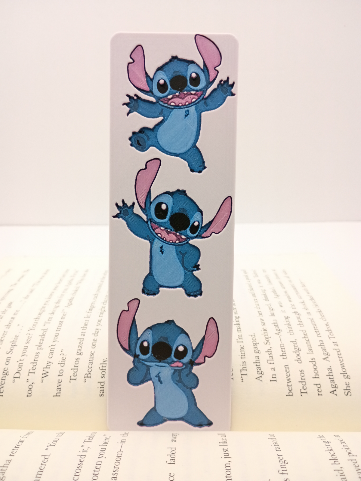 Marque-page Stitch blanc avec trois poses joyeuses et expressives