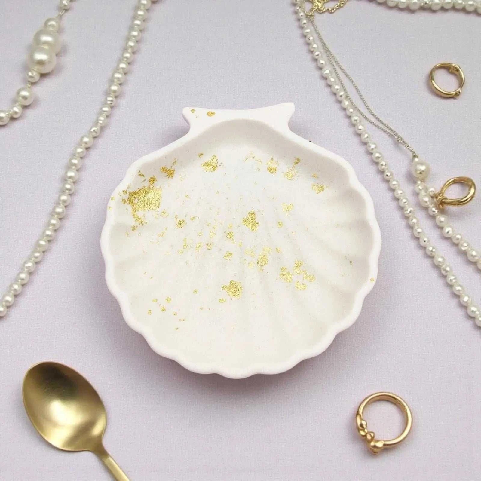 Vide-poche coquillage blanc en Jesmonite avec feuilles dorées, artisanat français élégant et écologique.