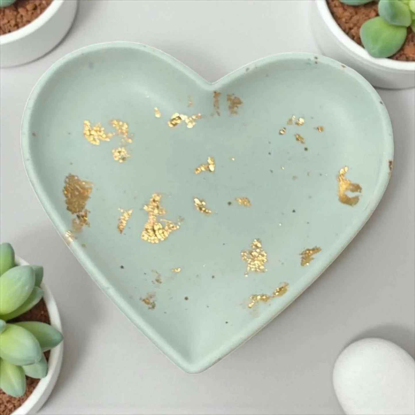 Vide-poche en forme de cœur vert eau en Jesmonite avec feuilles dorées, finition satinée et artisanale.
