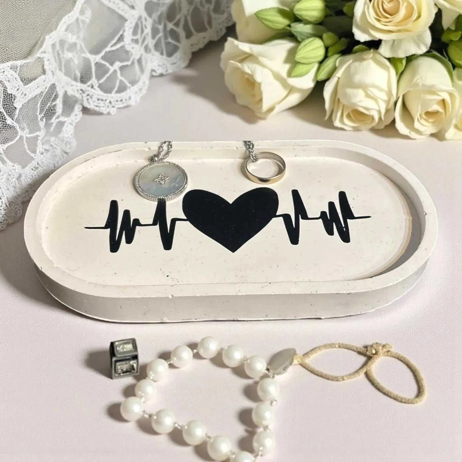 Vide-poche Jesmonite blanc avec cœur noir et battement, design minimaliste et artisanal.