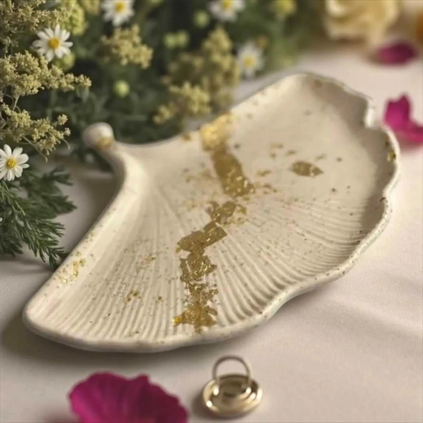 Vide-poche beige en Jesmonite avec feuille d’or représentant une feuille de Ginkgo, artisanal et élégant.