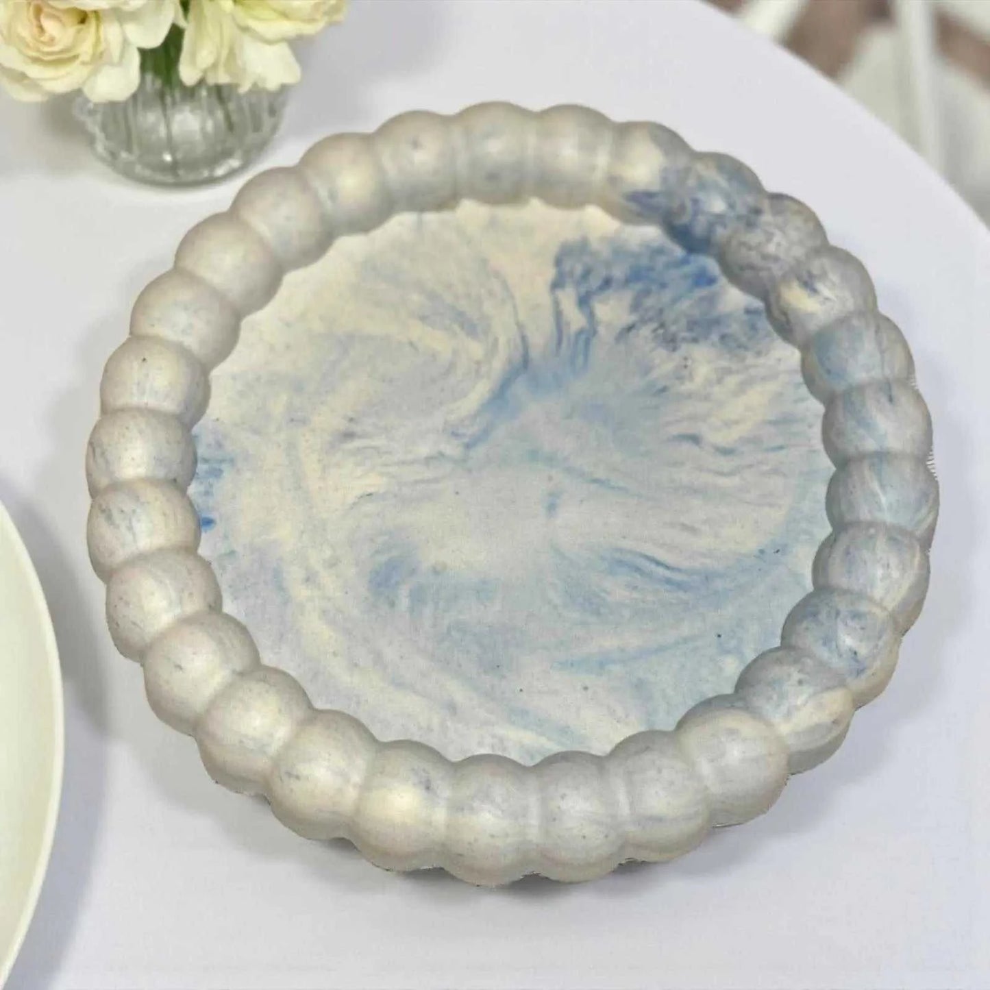 Vide-poche marguerite en Jesmonite bleu marbré clair, finition satinée, fait main, décoration zen et élégante.