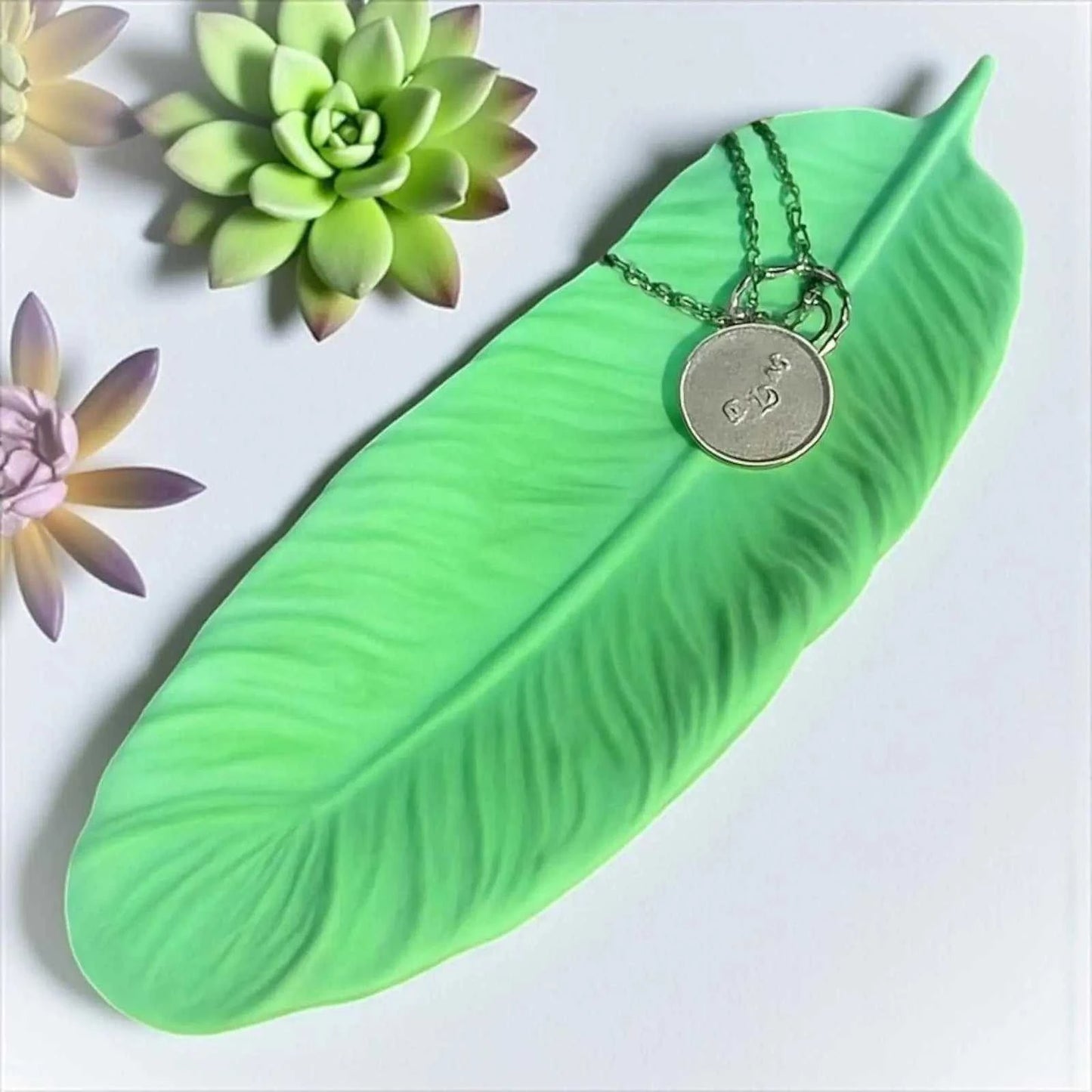 Vide-poche plume vert tendre en Jesmonite naturelle, création artisanale texturée, finition satinée effet pierre, décor zen, 24x8 cm.