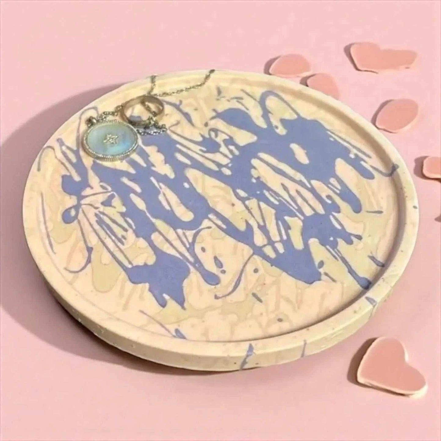 Vide-poche rond artisanal en Jesmonite beige avec éclaboussures rose et violet, décor moderne et coloré.